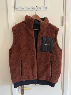 Vändbar fodradväst  - Två västar i en.  Mycket lite använd så i nyskick helt utan fläckar