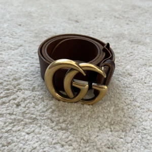 GUCCI BÄLTE ÄKTA - Hej! Säljer ett äkta Gucci bälte, är använt så finns en del skador. Kan skicka mer bilder vid förfrågan.  Storlek är 81,5 cm från mittenhålet till där man knäpper.  Kan skickas om köparen betalar frakten.  /Kim
