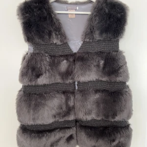 Pälsväst UnMade Copenhagen - Obs inte äkta päls! Pälsen är konstgjord men ser inte fake ut. Använd 2 gånger. Jättefint skick, endast 1 liten slitning vid insidan som går att se på sista bilden. Syns ej när västen är på. Den går att knäppa med 2 knappar (bild 1).