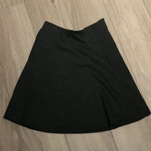 Grå kjol - Kjolen ser rätt mörk ut på bilden men den är grå i verkligheten. Kan skicka fler bilder om de så önskas. Frakt adderas på det nuvarande priset 