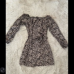 Axelklänning Leopard  - Tunt tyg, skärp i midjan 