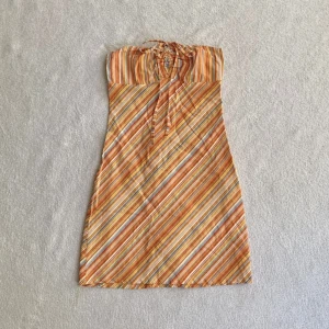 Randig klänning - Flerfärgad klänning i randigt mönster med band som kan knytas runt halsen, från märket Xanaka! 🧡