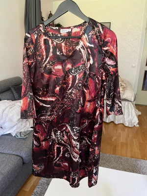 Klänning - Mönstrad klänning i satin och i väldigt fint skick, använt fåtal gånger.