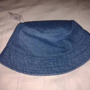 Oanvänd blå bucket hat i denim. Bomull. One size.