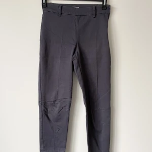 Ankellånga slacks från H&M storlek 34 - Märke: H&M Vad: Ankellånga slacks, dragkedja i sidan Storlek: 34 Upplevd i storlek: Stora, passar mig som brukar ha 36 Färg: Marinblå Material: Vet ej då jag klippt bort lappen, men skulle chansa på bomull & elastan Skick: Inget att anmärka på 