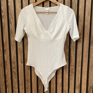 H&M body st.S - Säljer en body från H&M i storlek S, endast använd en gång så är i jättefint skick.