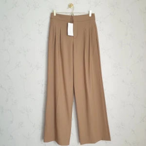 Bruna byxor - 🤎FÖSRT TILL KVARN!🤎 Flowy bruna byxor från Zara. Helt nya och oanvända med lapp kvar. Är ganska kort och skulle sy upp byxorna men har aldrig blivit av.😭Därför förtjänar de vara använda av någon annan som älskar byxorna❤️ Vill bli av med ASAP.🤗
