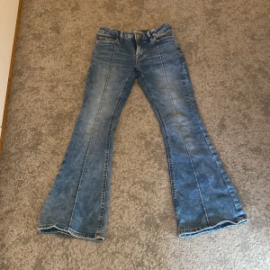 Jeans barn  - Low waist flare jeans från Lindex, barn strl 140, fint skick med fina detaljer på framsida och baksida. Jag på bilden är 147 och dom är lite korta på mig🩷