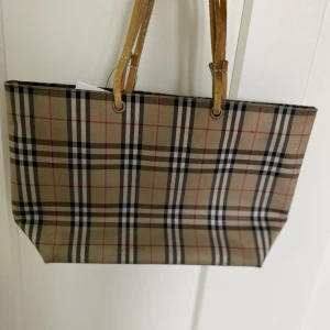 Burberry väska  - En Burberryväska som jag köpte på luxurybyho (vintage) och jag har aldrig använt den. Har enstaka fläckar och är lite sliten på handtagen men inget som man ser från avstånd ❤️ 