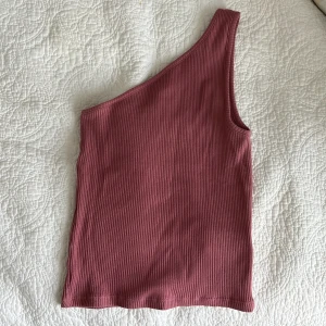 Topp - Jättesnyggt one- shoulder linne i ribbat material, knappt använd, från Urban Outfitters!