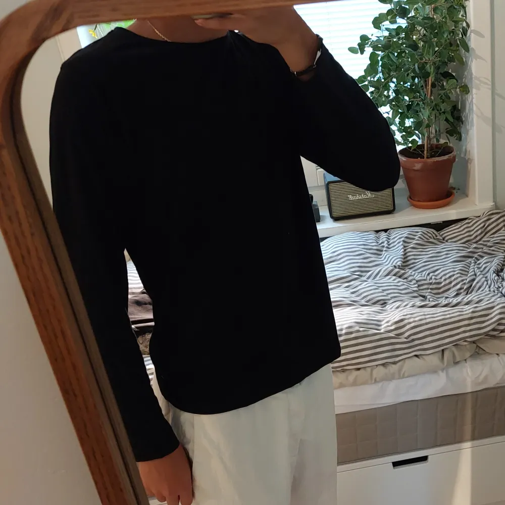 Svart långärmad tröja som är ett perfekt basplagg och går att styla med nästan vad som helst. Aldrig använd och är alltså i väldigt gott skick. Står att den är storlek 170 men sitter bra på min bror som är S.. Tröjor & Koftor.