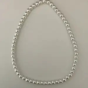 Vitt pärlhalsband av vita skinande glaspärlor, handgjort av elastisk tråd. Kontakta gärna vid frågor, köpare står för frakt. Har också andra smycken på min profil.