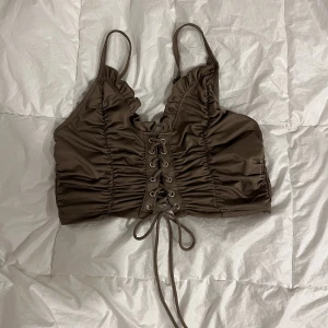 Brun topp - Superfin brun crop top med superstretchigt material. Knappt använd, toppskick. Strl S men passar M också. Katt finns i hemmet <3