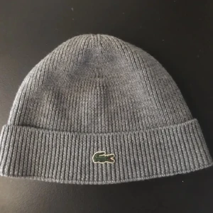 Grå lacoste  mössa - Hej! Säljer nu min gråa Lacoste mössa. Den är i fint skick och inte använd så mycket. Hör gärna av dig vid intresse!!😁