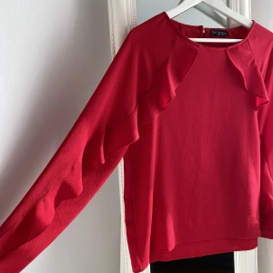 Röd blus - En jättefin hallonröd blus med volang! Bra skick och använd ett fåtal gånger!