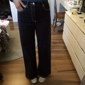 Marinblåa jeans med vitsöm.