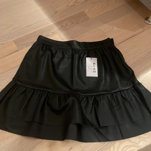 Frill PU skirt - Säljer denna skinn kjol som är helt oanvänd med etiket på. Köpte den på nakd.