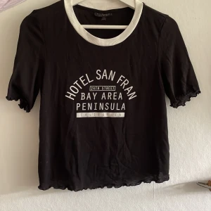 Tight T-shirt med tryck - Tight men stretchig svart T-shirt med lagom tryck från Topshop. Fin detalj på ärmararna!