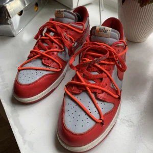 Nike Dunk Off-White University Red - Skicket är 7?/10. Boxen har tre repor, men är lagad och ser okej ut. Zip-tagen finns även den och följer givetvis med! Fler bilder kan fås i meddelande!  Kika gärna in mina övriga annonser!