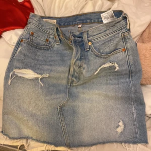 Jeanskjol - En jeanskjol från LEVIS i storlek 26.  Inga defekter och super fint skick.   Använd ca 5 gånger.   Köparen står för frakten 