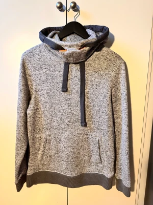 Grå Hoodie SuperDry - En grå Hoodie av märket SuperDry. Lite stretchig i materialet. Gott skick