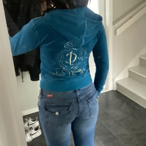 Juicy couture ziptröja  - Blå ziptröja från juicy couture som jag använt en gång. Det är en gammal tröja då den inte säljs längre. Kom privat för bättre bilder. Luvan är väldigt liten. Osäker på storleken (tror det är 34) men lite kort på mig som har 36 i tröjor. ☺️