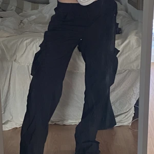 Lågmidjade cargobyxer - Lågmidjade svarta cargobyxor från HM, använda 1 gång, i storlek 34