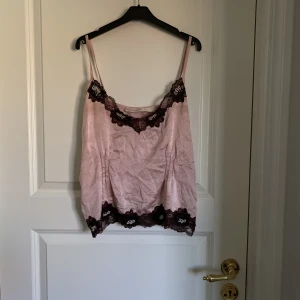 SpetsLinne - Ett vackert linne med blomspets och pärlor i storlek M, passar även S💗Det är lite slitet (se bild 3) men syns inte lika tydligt när man bär det, annars går det att fixa☺️Kontakta mig vid frågor!