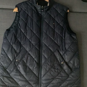 Tommy hilfiger väst - Säljer en tvär fet Tommy hilfiger väst som tyvärr har blivit för stor. Västen är dubbelsidig vilket innebär att man kan variera när man känner för de. 