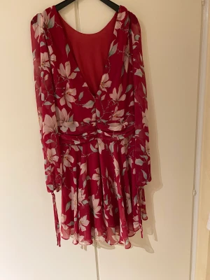 Somrig klänning - En bloomig klänning med öppen rygg. Haft på mig den en gång. Tunnt material som gör att den är bekväm att ha på sommaren men är inte genomskinlig 