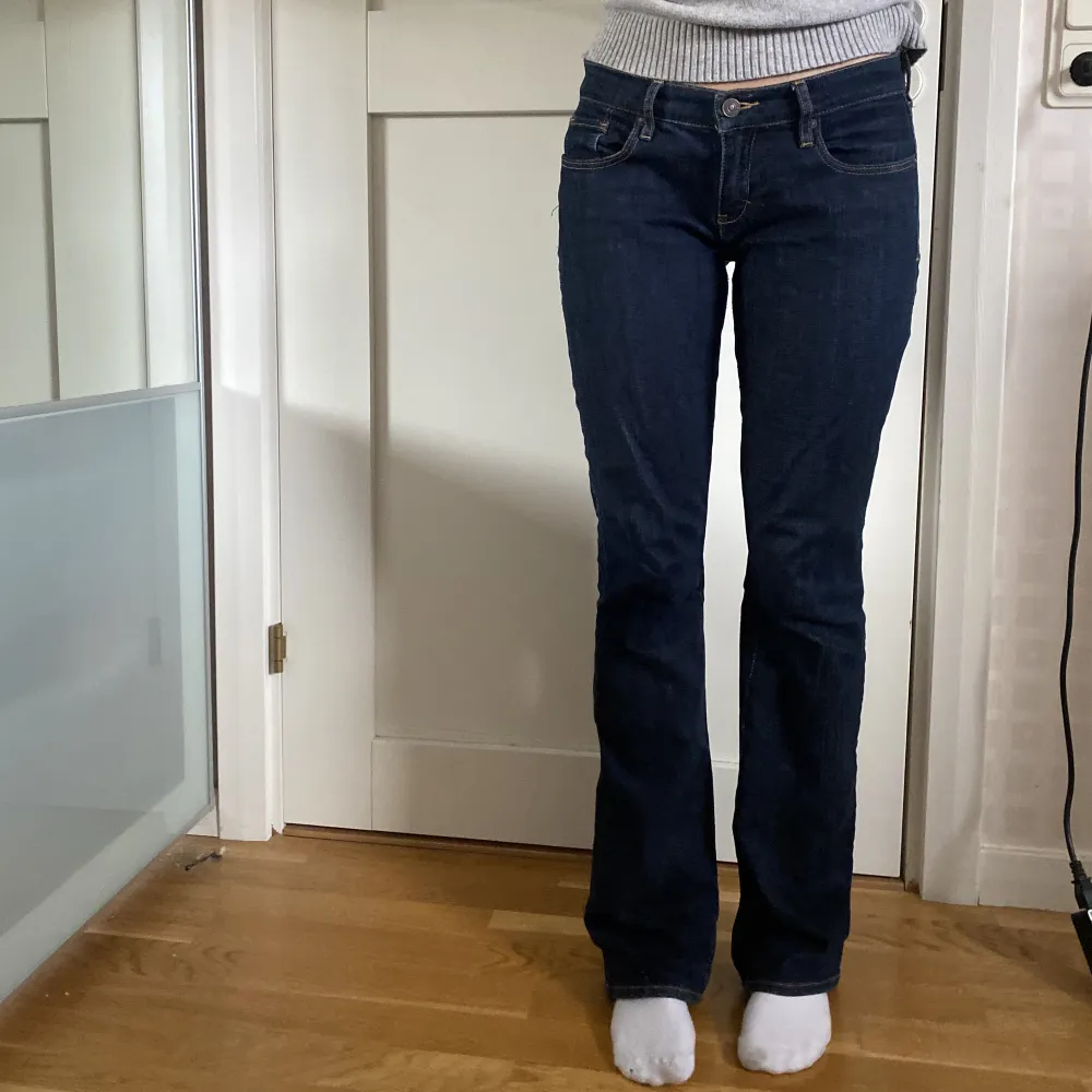 Mörkblå lågmidjade jeans med snygga detaljer på fickorna. Midjemått 39 cm rakt över. Innerbenslängd 80 cm. Jag är 163 cm på bilderna. Kan skicka bilder privat. . Jeans & Byxor.