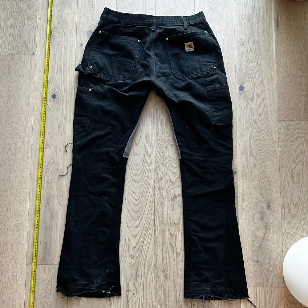Reworked Carhartt Doubleknee med flare och extra grå detals vid insida lår. Storlek W30 L32. Mörk blå svart färg. Jeans & Byxor.