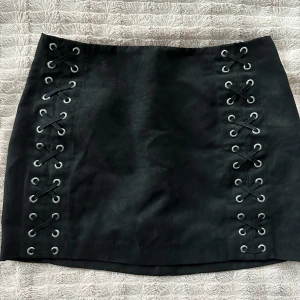 Svart kjol - Snygg svart kjol från H&M i storlek 38. Snörningsdetaljer framtill. 