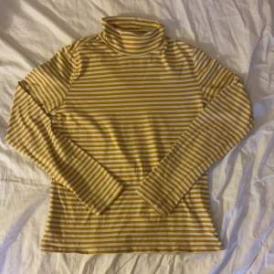 En gul och vit randig tröja i storlek S. Den har en halv turtleneck och är extremt bekväm. Säljer då jag sällan använder den.