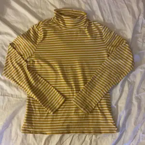 En gul och vit randig tröja i storlek S. Den har en halv turtleneck och är extremt bekväm. Säljer då jag sällan använder den.