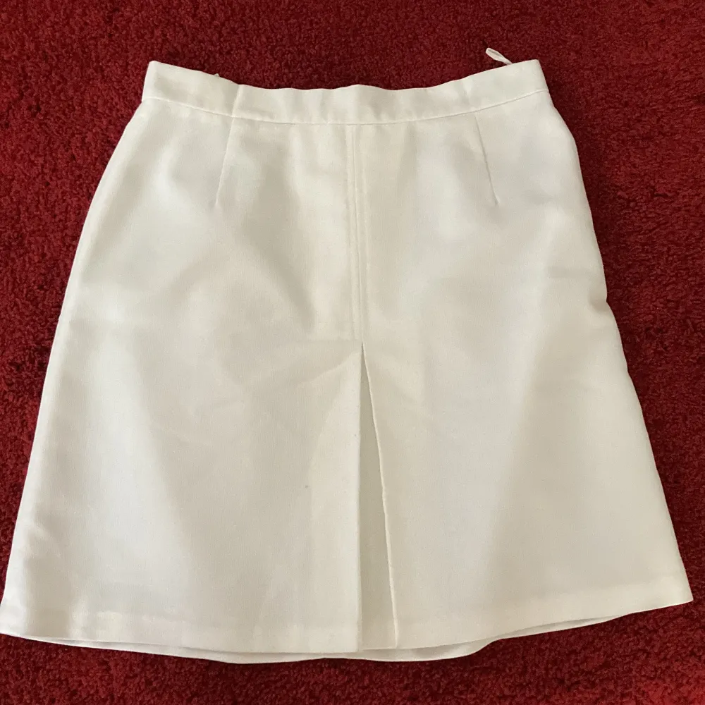 Snygg vit kjol med slits bak! Den är i storlek 38 men skulle även säga att den passar 36🤍knappt använd alls och i fint skick. 40+frakt!. Kjolar.
