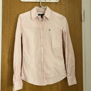 Rosarandig skjorta i storlek 34