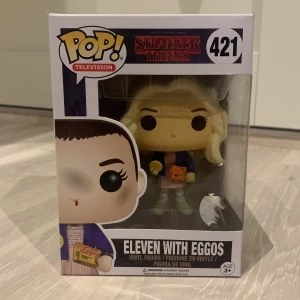Eleven Stranger Things Funko Pop - Stranger Things Eleven funko pop figur, #421. Figuren har tagits ur lådan men både lådan och figuren är i bra skick. Pris kan diskuteras, jag vill mest bli av med den.
