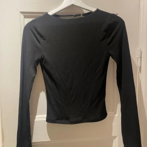 Svart topp med öppen rygg - Svart topp från BikBok med öppen rygg. Storlek XS, sparsamt använd. Hör gärna av dig vid frågor☺️