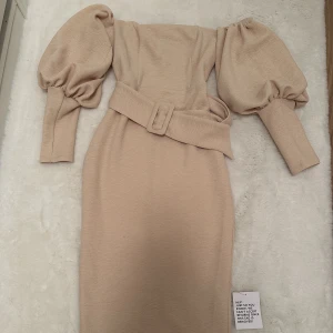 Texturerad fodralklänning i off shoulder  - Storlek 36   Aldrig använd   Stretchtyg och sitter tight på kroppen med puffärmar 