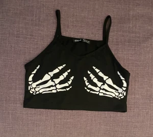 Croptop Xs  - Jätte fint linne me skelet händer på brösten, passar perfekt till halloween dessutom, aldrig använt men haft ett tag, bra material utan märken eller hål, pris kan diskuteras 