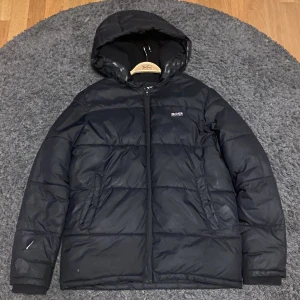 Hugo Boss Jacka  - Hej säljer nu min gamla vinter jacka i märket Hugo Boss som kostar 3000 + kr ny, Det är en varm och skön dunjacka med en skada på höger hand, Priset är ej hugget i sten kom dm för frågor eller fundering MVH