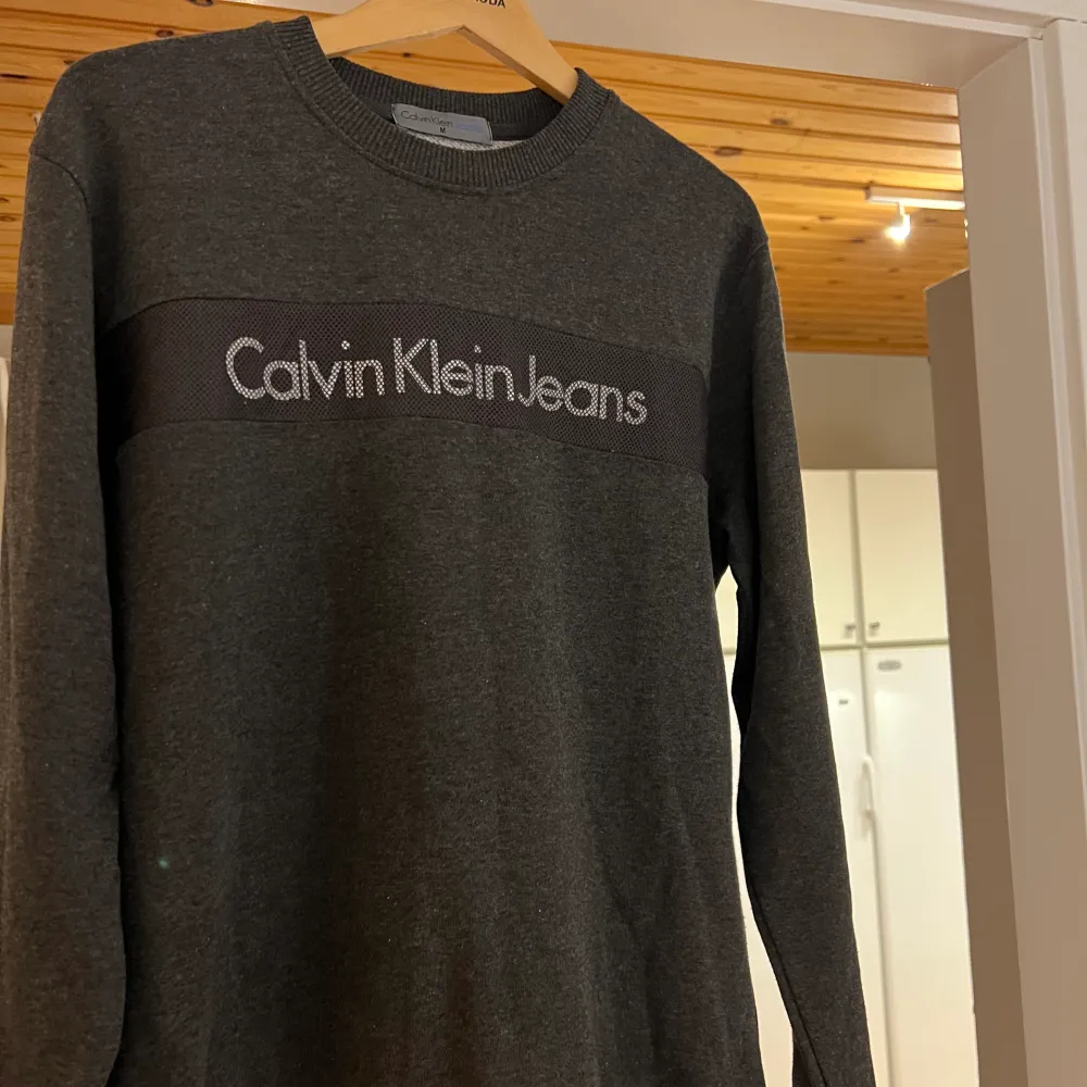 Mörkgrå tröja från Calvin Klein i nyskick. Storlek M där passformen är något loose.. Tröjor & Koftor.