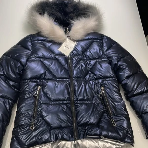 Vinterjacka  - Jacka från Lanyuxuan. Cool metallic blå färg och Silvrig på insidan. Står 3XL men är L/XL så liten i storlek.