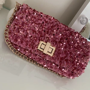 Glittrig väska 🩷 - Jättefint skick, endast använd ett par gånger på studentfest💜 slutsåld och orginalpris var 250 kr.  Har fri frakt på denna på en annan annons! 