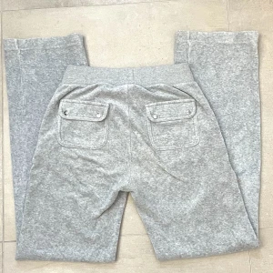 Juicy byxor  -  Ett par gråa juicy byxor i storlek s. Säljer pågrund av att de är för stora. Ni kan se två inringade fel på dem ifall ni kollar på bild 3! Materialet har blivigt lite sträft efter gången då jag råkade tvätta dem på för hög gradnivå💓