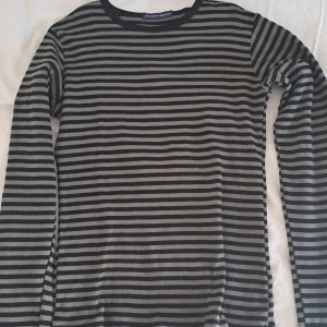 Brandy Melville tröja - Svart och mörkgrön/oliv randig tröja köpt från Brandy Melville.  Säljs då den inte används. Inga defekter. 