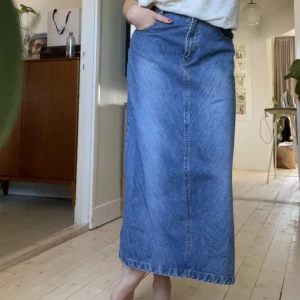 Ankellång jeanskjol - Säljer denna fina jeanskjol då den inte kommer till användning. På mig som är 38 sitter den högmidjat, men om man vill ha att den ska sitta mer lågmidjat skulle jag säga att den passar en 36a! 😇