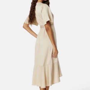 Helt oanvänd Midi klänning bubbleroom - Säljer en helt oanvänd klänning från Bubbleroom Occasion.  Köptes för 799kr men säljer för 400 Champagne färgad i str XS