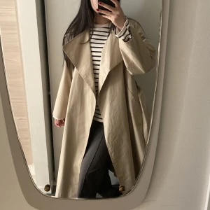 Trenchcoat från Mango - Säljer superfin, populär trenchcoat från mango i så fin beige färg. Perfekt nu till våren och oanvänd😊 Otroligt fin passform, märks att det är bra kvalitet💘Ordinarie pris 1200kr. Lite stor i storleken så xxs passade mig som brukar ha xs-s. 